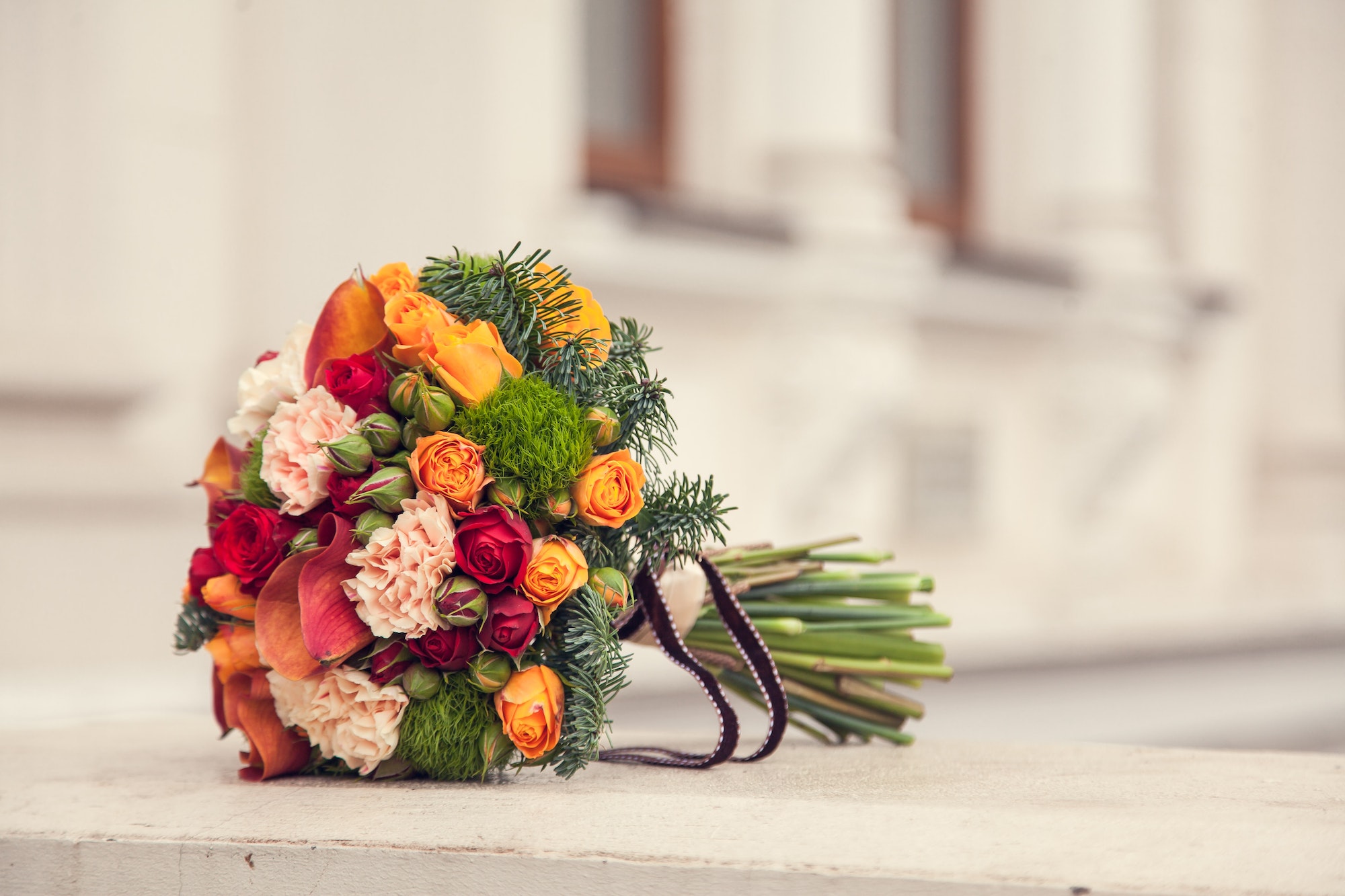 Bridal bouquet in winter or autumn style with carnation, roses, buds, spruce, calla flower
